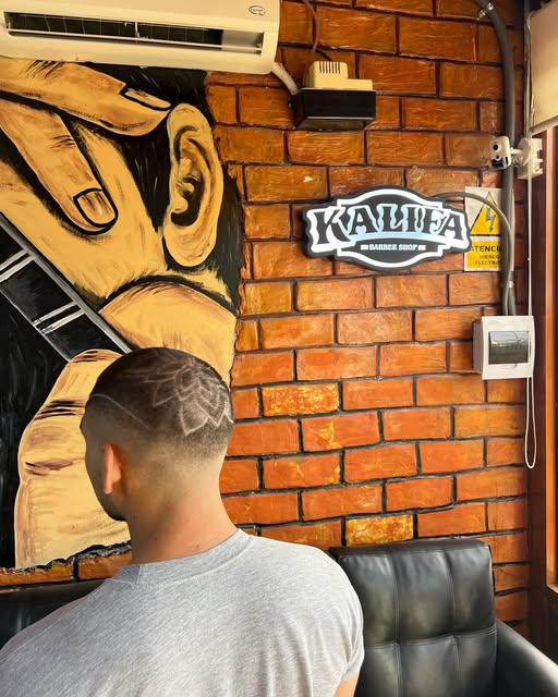 Corte con diseño y el mural de Kalifa al fondo